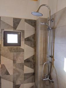 a bathroom with a shower with a tv on the wall at Villas Irene 3 Family Apartments in Gournes