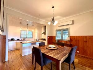 a large kitchen with a wooden table and chairs at Cherry Blossom Cottage - Beechworth-Getaways in Beechworth
