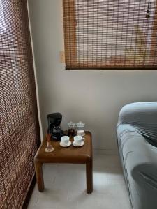 Una pequeña mesa con dos tazas y una cafetera. en Muse Manizales, en Manizales