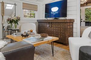 a living room with a table and a tv at The Black Nest - Hot Tub Romantic Getaway in Guerneville