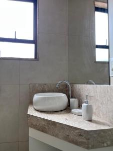 a bathroom with a sink and a mirror at STUDIOS CORACAO EUCARISTICO in Belo Horizonte