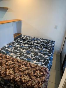 - une petite chambre avec un lit et une couverture à motifs dans l'établissement Crespo Suites, à Rosario