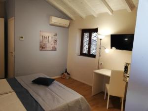 1 dormitorio con cama, escritorio y ventana en Corteallago en Moniga