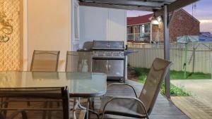 a patio with a glass table and a stove at Canowindra Riverview Motel in Canowindra