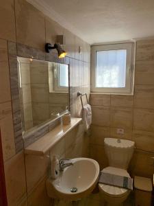 uma casa de banho com um lavatório, um WC e uma janela. em VillAri Lefkas Suites em Exanthia