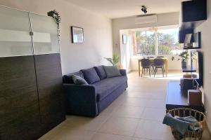 a living room with a blue couch and a table at Your Luxurious Home Near The Dunes! in Playa del Ingles