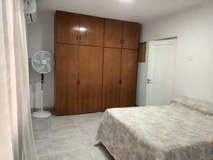 1 dormitorio con 1 cama y armario de madera en Casa hasta 10 personas. en Villa Rumipal