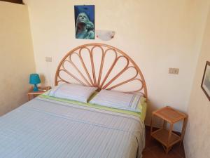 a bedroom with a large bed with a wooden headboard at Monolocali in centro paese in Lampedusa