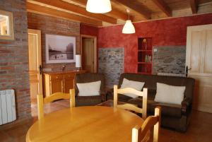 sala de estar con mesa de madera y sillas en La Senra, en León