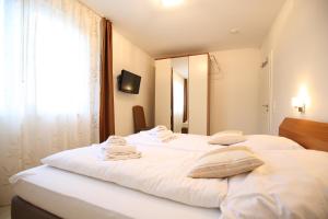 a bedroom with two white beds and a mirror at Villa Verdi - Ferienwohnung 4 in Wangerooge