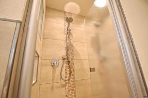 La salle de bains est pourvue d'une douche et d'une porte en verre. dans l'établissement Villa Verdi - Ferienwohnung 4, à Wangerooge