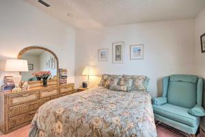 a bedroom with a bed and a blue chair at Lady Lake House with Lanai and Community Pool! in Lady Lake