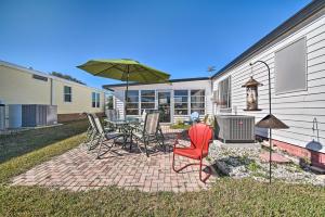 a patio with a table and chairs and an umbrella at Lady Lake House with Lanai and Community Pool! in Lady Lake