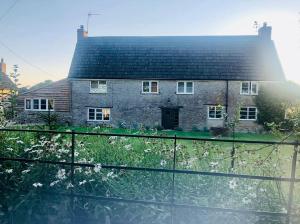 a house with a fence in front of it at The Snug at Caphays: perfect rural retreat in Long Burton