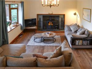 a living room with a couch and a fireplace at Rowan House in Glencripesdale