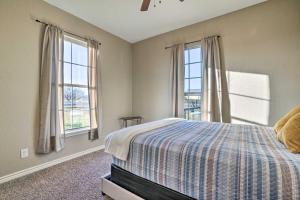 een slaapkamer met een bed en 2 ramen bij Peaceful Atascosa Home with Balcony and Deck! in Lytle