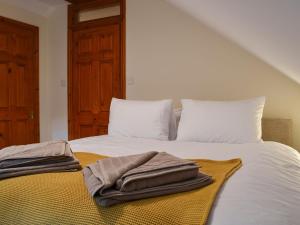 uma cama com toalhas em cima em Rowan House em Glencripesdale