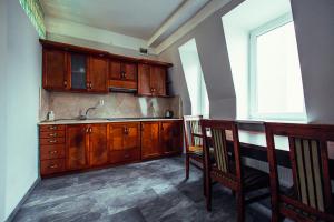 una cucina con armadi in legno, lavandino e finestra di Hotel - Apartamenty Heban a Toruń