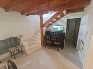a room with a staircase and a table and chairs at Casaquinta en la costa del Rio in General Roca