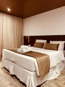 1 dormitorio con 1 cama grande con sábanas blancas en Refúgio da Rita, en Fernando de Noronha