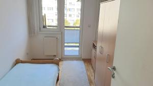 a bedroom with a bed and a large window at ELEGANCE Apartment in Sarajevo