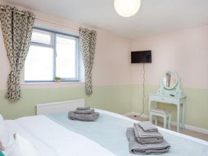 a bedroom with a bed and a window and a mirror at Jubilee Cottage in Dawlish