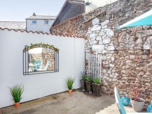 a white garage with a window and a stone wall at Jubilee Cottage in Dawlish