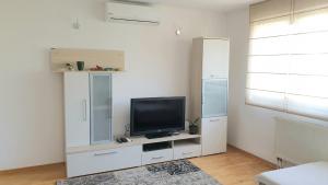 a living room with a television on a white cabinet at ELEGANCE Apartment in Sarajevo
