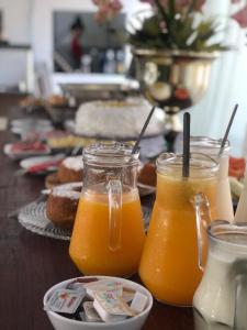 dos jarras de jugo de naranja sentadas en una mesa en Hotel Rainha, en Itapoa