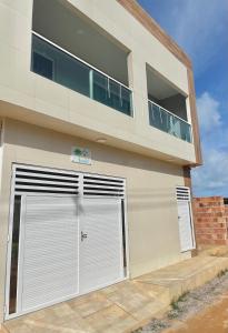 un edificio con dos puertas de garaje delante de él en Casa Flat Caminho da Praia, en Maragogi