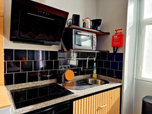 a kitchen with a sink and a microwave at ASPA - São Paulo Studios in Funchal