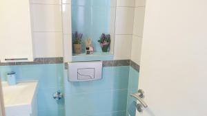a bathroom with blue tiles and a sink and a mirror at ELEGANCE Apartment in Sarajevo +20 photos