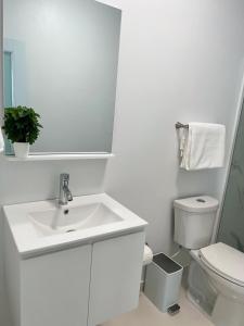 a white bathroom with a sink and a toilet at San Juan Home in San Juan