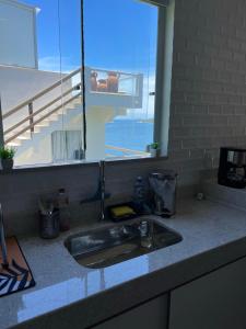 encimera de cocina con fregadero y ventana en Casa aconchegante Pontal do Atalaia Vista Mar, en Arraial do Cabo