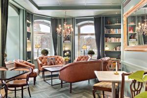 een woonkamer met stoelen, tafels en boekenplanken bij Best Western Hotel Baltic in Sundsvall