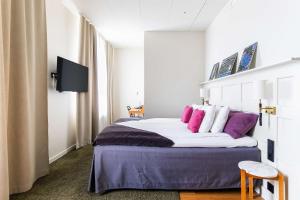 una camera da letto con un letto con cuscini viola e bianchi di Best Western Hotel Baltic a Sundsvall