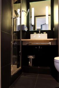 een badkamer met een wastafel, een toilet en een spiegel bij Best Western Hotel Opéra Drouot in Parijs