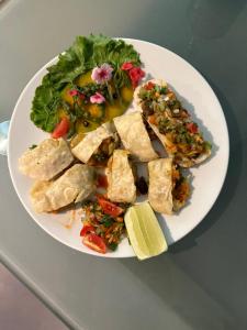 a white plate of food with a salad and tofu at Contemporary Heights Hotel and Apartments in Dhaka