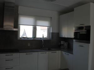a kitchen with a sink and a window with a boat in it at Holiday Home in Zeeland with Garden in Wemeldinge