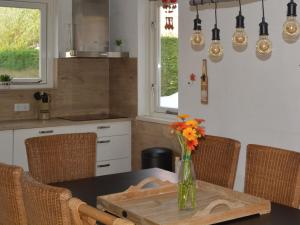 a kitchen with a table with a vase of flowers on it at Holiday Home in Quiet Park for Families in Wemeldinge