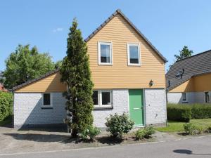 a house with a green door on a street at Holiday Home in Quiet Park for Families in Wemeldinge