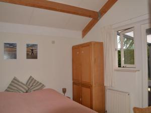 a bedroom with a bed and a cabinet and a window at Holiday Home in Quiet Park for Families in Wemeldinge
