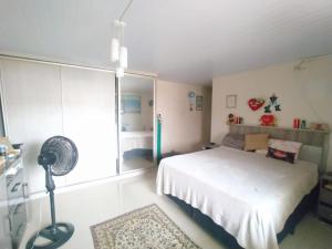 1 dormitorio con cama blanca y ventana en Casa de férias, en Bombinhas