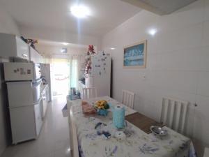 una pequeña cocina con mesa y nevera en Casa de férias, en Bombinhas