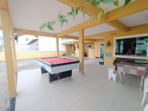 una mesa de billar en el medio de una habitación en Casa de férias, en Bombinhas