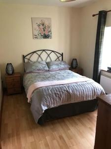 1 dormitorio con 1 cama y suelo de madera en Castlegregory-Seaside 2 Bedroomed Cottage en Castlegregory