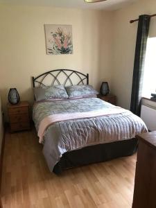 a bedroom with a bed and a wooden floor at Castlegregory-Seaside 2 Bedroomed Cottage in Castlegregory