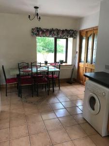a kitchen with a table and a dining room with a washing machine at Castlegregory-Seaside 2 Bedroomed Cottage in Castlegregory