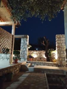 a stone building with a window and a tree at night at Tonea's Houses in Himare