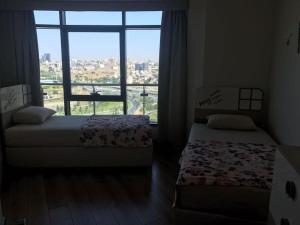 - 2 lits dans une chambre avec une grande fenêtre dans l'établissement mall of istanbul, à Basaksehir
